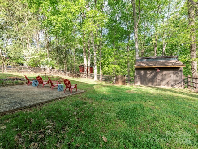 view of yard featuring fence, an outdoor structure, and a storage unit