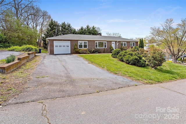 ranch-style home with a front yard, brick siding, an attached garage, a chimney, and driveway