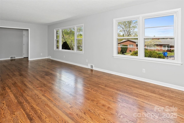 unfurnished bedroom with dark wood-type flooring, baseboards, and visible vents