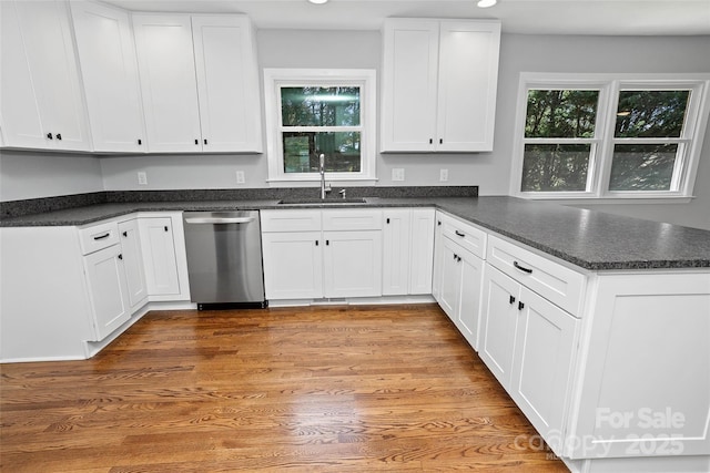 kitchen featuring recessed lighting, a peninsula, white cabinetry, stainless steel dishwasher, and a sink