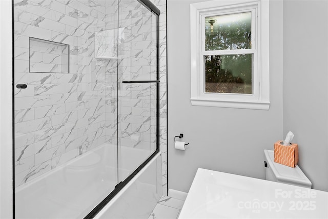 bathroom featuring shower / bath combination with glass door, marble finish floor, and baseboards