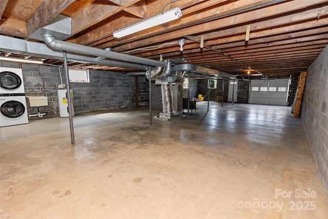 below grade area with stacked washer and clothes dryer, a sink, and water heater