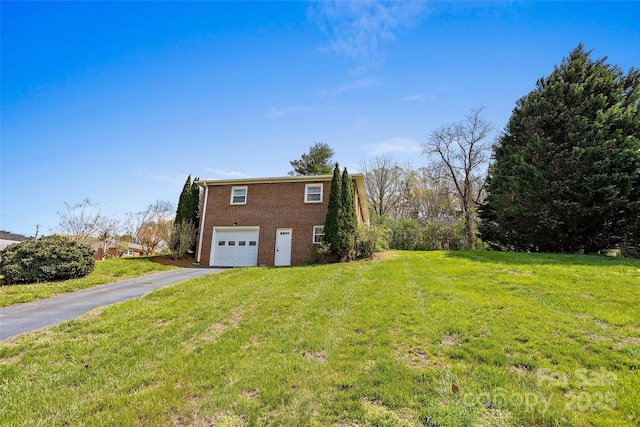 view of side of home with brick siding, an attached garage, driveway, and a lawn