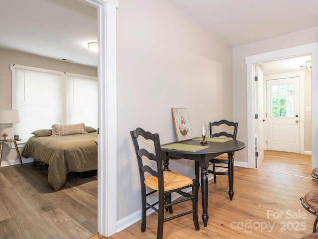dining area featuring light wood-style flooring and baseboards