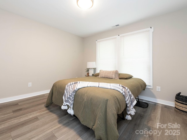 bedroom featuring wood finished floors and baseboards