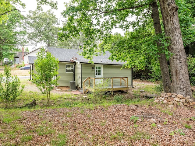 back of house with a wooden deck, roof with shingles, and central air condition unit