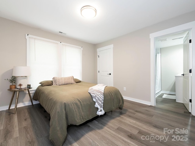 bedroom featuring wood finished floors and baseboards