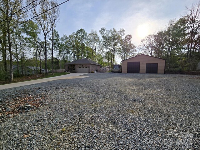 view of front facade with a detached garage, an outbuilding, and a pole building