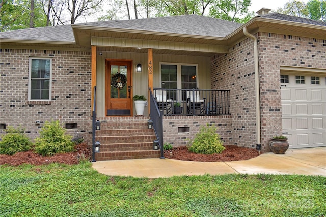 view of exterior entry with crawl space, covered porch, brick siding, an attached garage, and a shingled roof