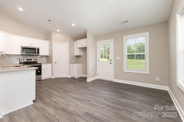 115 Frances St, Salisbury, NC 28147 - kitchen featuring appliances with stainless steel finishes, decorative backsplash, lofted ceiling, dark wood-style flooring, and white cabinetry