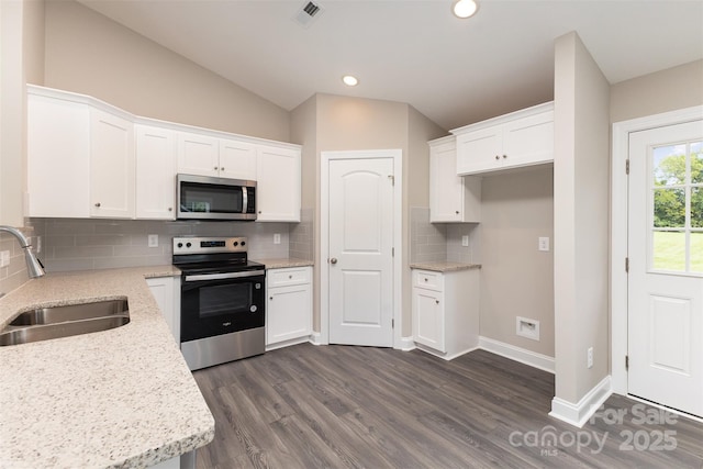 115 Frances St, Salisbury, NC 28147 - kitchen with appliances with stainless steel finishes, lofted ceiling, white cabinets, dark wood-style flooring, and backsplash