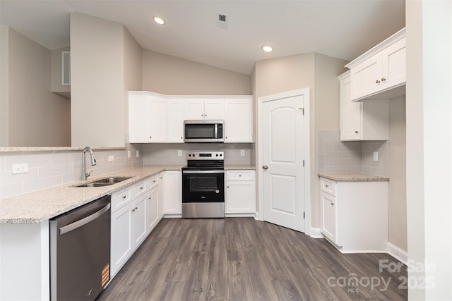 115 Frances St, Salisbury, NC 28147 - kitchen with appliances with stainless steel finishes, backsplash, dark wood-style flooring, lofted ceiling, and white cabinetry