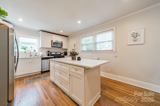 3510 Conway Ave, Charlotte, NC 28209 - kitchen with appliances with stainless steel finishes, ornamental molding, light wood finished floors, healthy amount of natural light, and decorative backsplash