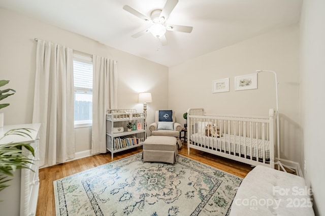 3510 Conway Ave, Charlotte, NC 28209 - bedroom featuring wood finished floors, a crib, a ceiling fan, and baseboards