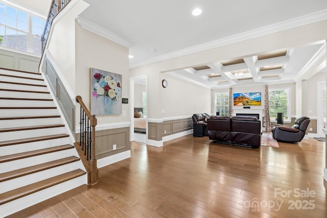 interior space with beam ceiling, crown molding, coffered ceiling, and wood finished floors