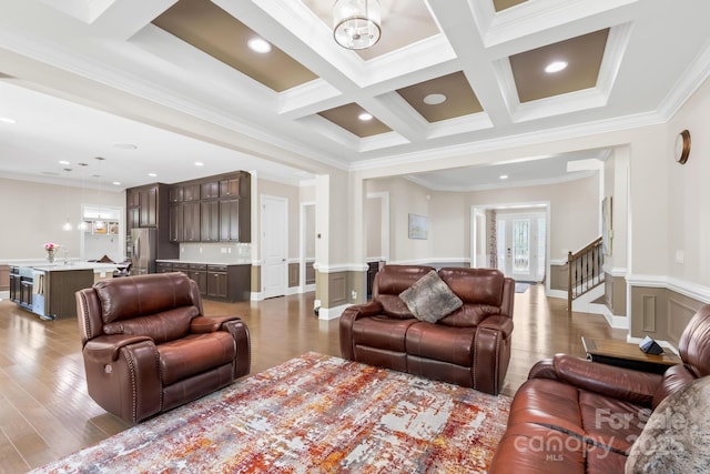 living room with crown molding, coffered ceiling, wood finished floors, and a healthy amount of sunlight