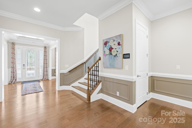 entrance foyer featuring a decorative wall, ornamental molding, recessed lighting, wood finished floors, and a wainscoted wall