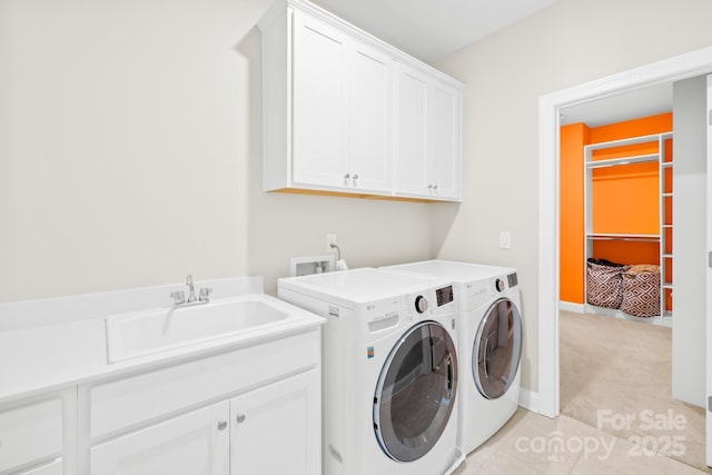 laundry area featuring a sink, light colored carpet, cabinet space, and separate washer and dryer