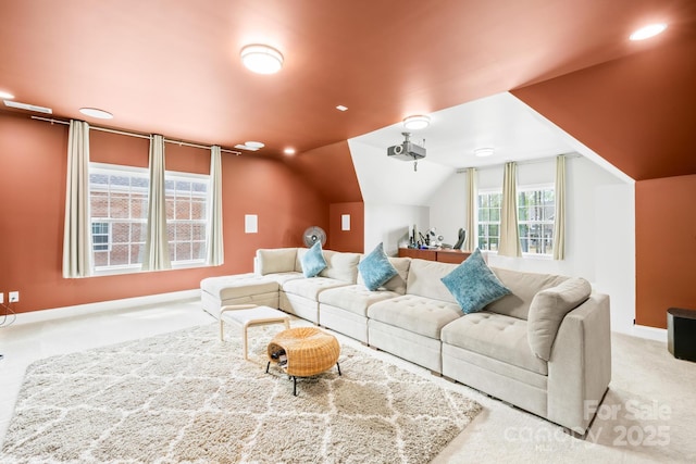 living area featuring carpet, baseboards, and vaulted ceiling