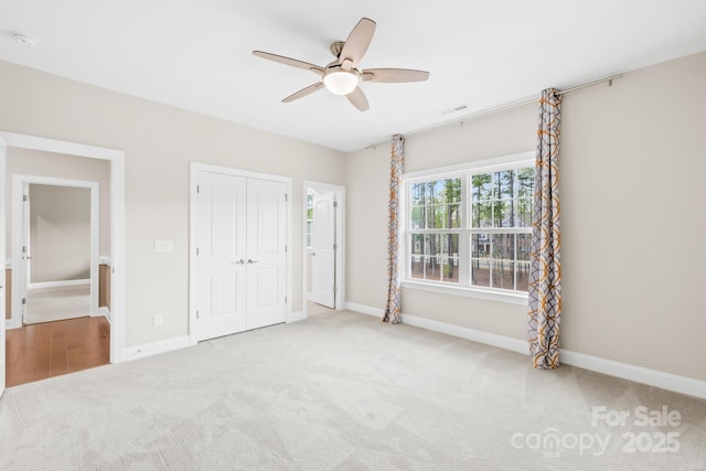 unfurnished bedroom with a closet, carpet, visible vents, and baseboards