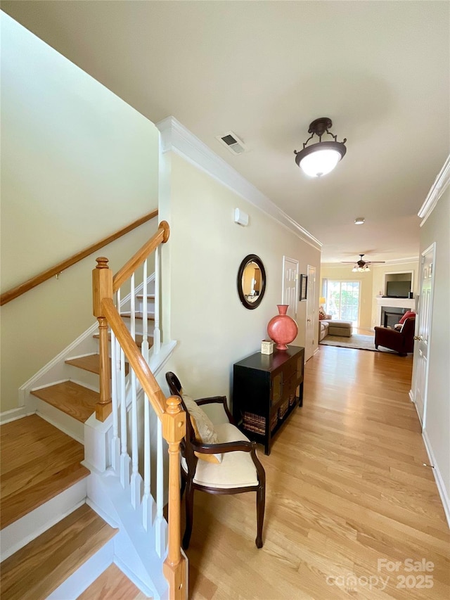 14022 Drake Watch Ln, Charlotte, NC 28262 - stairway with visible vents, baseboards, a fireplace, crown molding, and wood finished floors