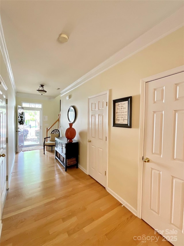 14022 Drake Watch Ln, Charlotte, NC 28262 - hallway featuring stairs, light wood-style floors, baseboards, and ornamental molding
