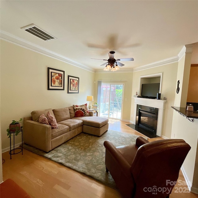 14022 Drake Watch Ln, Charlotte, NC 28262 - living room featuring ornamental molding, a ceiling fan, a fireplace with flush hearth, visible vents, and wood finished floors