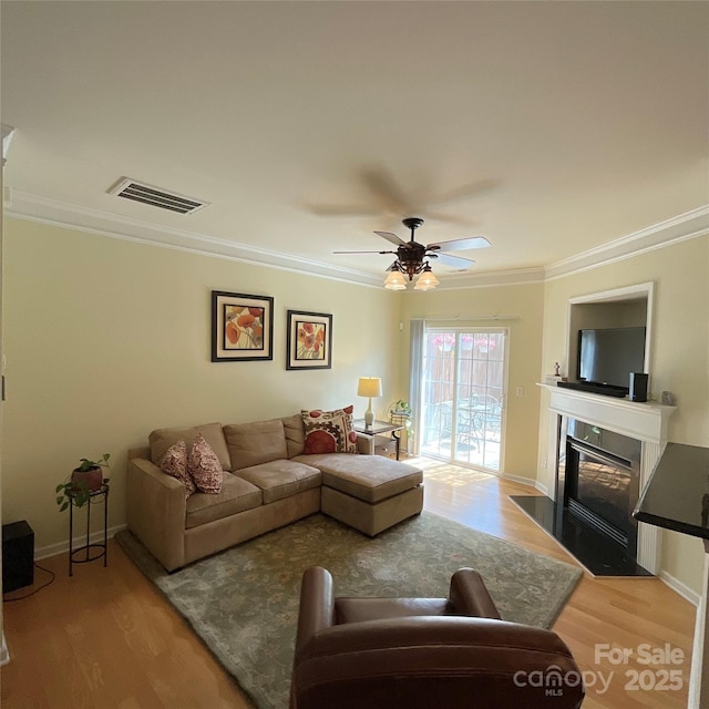 14022 Drake Watch Ln, Charlotte, NC 28262 - living room with a fireplace with flush hearth, light wood finished floors, ornamental molding, and visible vents