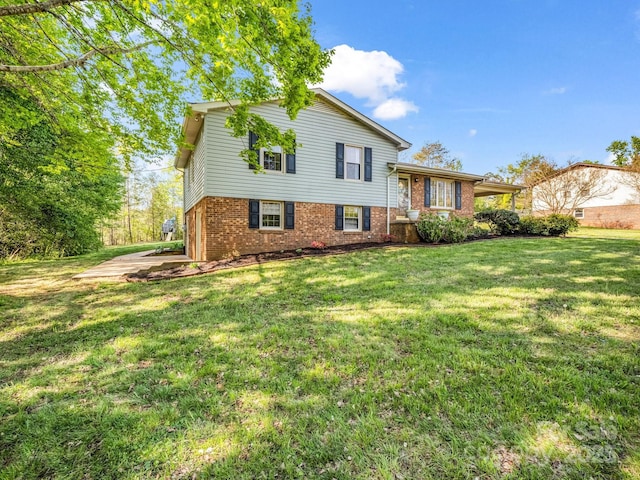 split level home featuring a front yard and brick siding