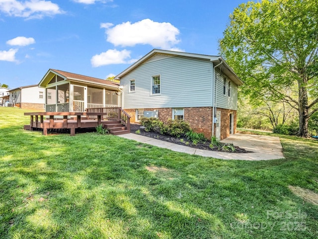 rear view of property with a garage, brick siding, a sunroom, and a lawn