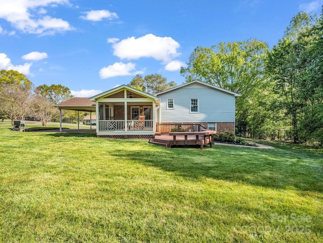 back of property with a wooden deck, brick siding, an attached carport, and a lawn