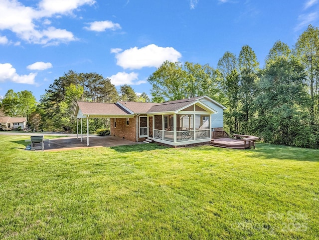 back of house featuring a carport, brick siding, and a lawn