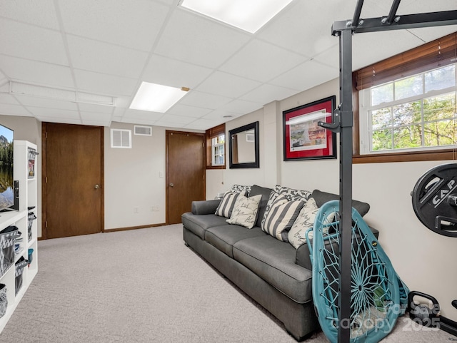 carpeted living room with visible vents and a paneled ceiling