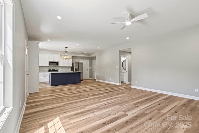 102 Kerda St, Taylorsville, NC 28681 - unfurnished living room featuring ceiling fan with notable chandelier, light wood-style flooring, baseboards, and recessed lighting