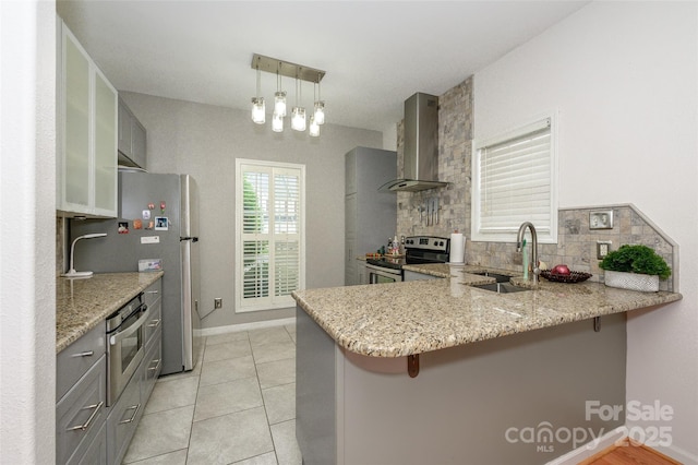 4133 Carl Parmer Dr, Harrisburg, NC 28075 - kitchen featuring a peninsula, wall chimney range hood, gray cabinets, a sink, and stainless steel appliances