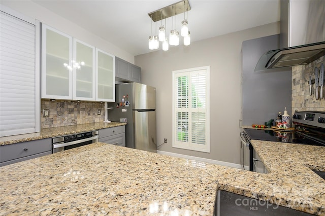 4133 Carl Parmer Dr, Harrisburg, NC 28075 - kitchen featuring gray cabinetry, light stone countertops, wall chimney exhaust hood, decorative backsplash, and appliances with stainless steel finishes