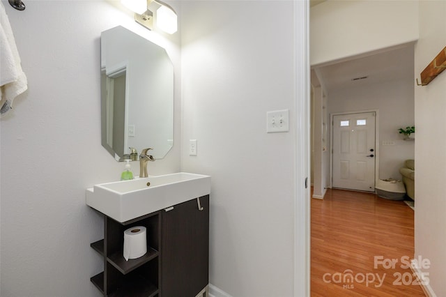 4133 Carl Parmer Dr, Harrisburg, NC 28075 - bathroom featuring a sink, baseboards, and wood finished floors