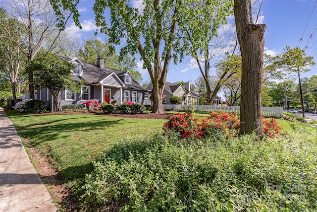 view of front of property featuring a front yard, fence, and a chimney