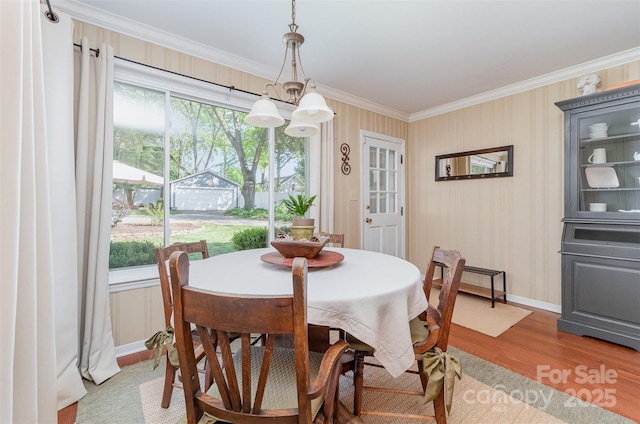 dining room featuring a wealth of natural light, crown molding, and wood finished floors