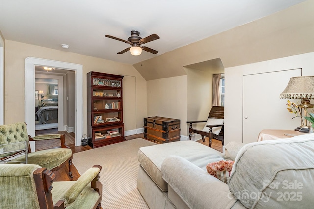 living room featuring ceiling fan, vaulted ceiling, wood finished floors, and baseboards