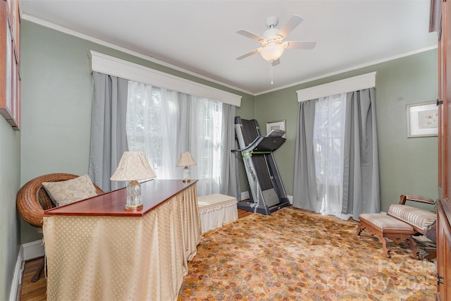 office space with crown molding, baseboards, and a ceiling fan