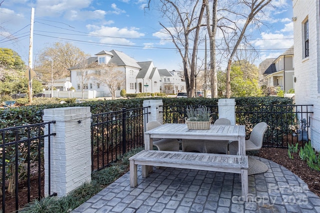 view of patio featuring a residential view, outdoor dining area, and fence private yard