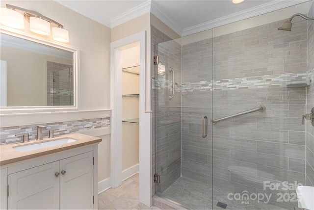 1329 Merrimon Ave, Asheville, NC 28804 - bathroom with crown molding, a walk in closet, vanity, decorative backsplash, and a stall shower