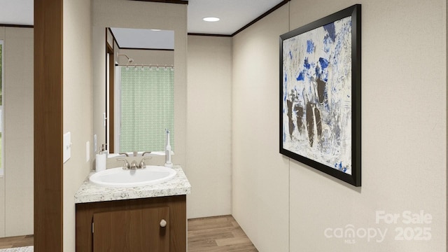 bathroom with vanity, curtained shower, and wood finished floors