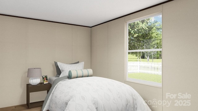 bedroom featuring ornamental molding, multiple windows, and wood finished floors