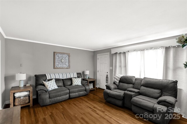 living area with wood finished floors, baseboards, and ornamental molding