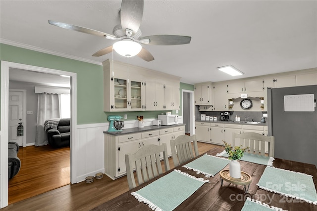 kitchen with white microwave, a sink, dark wood finished floors, and white cabinets