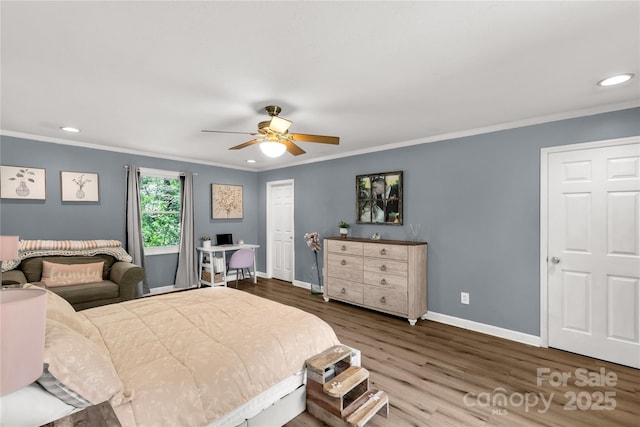 bedroom with recessed lighting, baseboards, crown molding, and wood finished floors