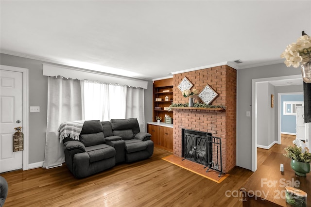 living room with crown molding, wood finished floors, a fireplace, and baseboards