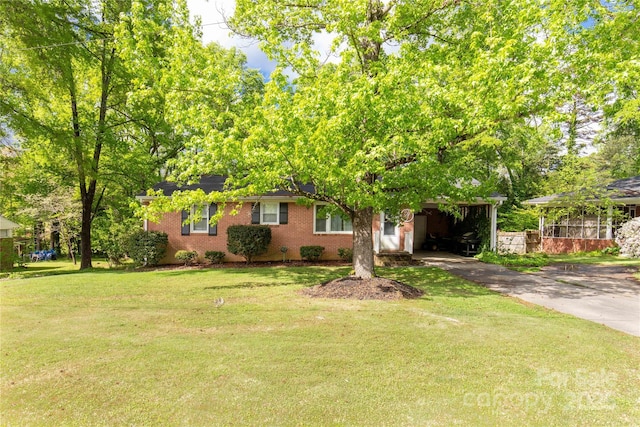view of front of home featuring driveway, a front yard, and brick siding